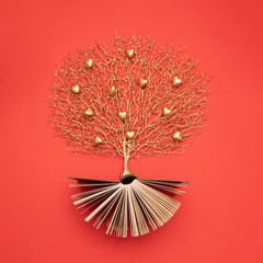 Wall Mural - Golden tree with heart shaped fruits growing from the old book, Education and knowledge concept. For book lovers. Flat lay.