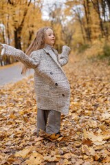 Wall Mural - Portrait of a fashion little girl having fun in autumn forest