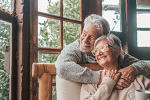 Portrait Of Couple Of Happy Mature People In Love Hugging And Looking At The Camera Smiling And Having Fun At Home. Two Cute Seniors Enjoying Indoors Together.
