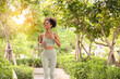 © bigy9950 - Happy black sportswoman running outdoors in the public park. Young female, afro hairstyle exercising in sportswear.