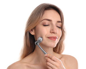 Young woman using metal face roller on white background