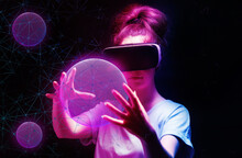 Portrait Of Young Woman In VR Glasses Creates 3D Simulation Of Pink Mesh Sphere. Dark Background With Neon Abstracts. The Concept Of Virtual Reality And Metaverse