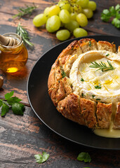 Wall Mural - Baked Camembert cheese in sourdough bread with rosemary, garlic, thyme