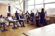 © Studio Romantic - Lecture and training in business office. Variety of business people listen to female business coach at educational meeting of company. Business audience sits on chairs and tables in loft office.
