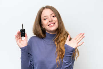 Canvas Print - Young caucasian woman holding car keys isolated on white background saluting with hand with happy expression