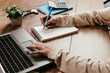 © Daniel - Woman typing on a laptop and writing in a notepad
