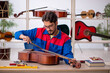 © Elnur - Young man repairing musical instruments at workshop
