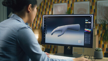 Wall Mural - woman sitting at the table at home office and making 3d prototype of human hand in professional prog