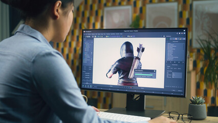 Wall Mural - female 3d designer creating and drawing character for video game using computer while sitting at the