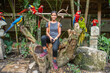 Tourist surrounded by macaws at Macaw Mountain, Copan Ruinas, Honduras