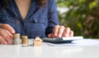 © sinseeho - Home keychain with woman on calculator and coins at the background. Property valuation or investment concept.