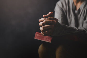 Christ religion and christianity worship or pray concept. Christian catholic woman are praying to god in dark at church. Prayer person hand in black background. Girl believe and faith in jesus christ.