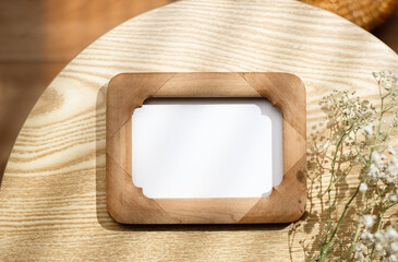 Wall Mural - mockup wooden photo frame on round table with evening sunlight