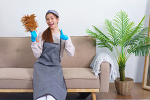 Housework Concept, Housemaid Is Holding Feather Duster And Thumbs Up Gesture After Cleaning House