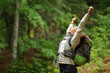 Hiker excited raising arms celebrating in a forest