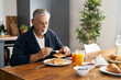 © gpointstudio - Senior caucasian man preparing breakfast at home