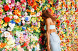 © Westend61 - Young curly hair woman leaning head on flower wall