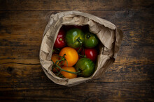Red, Green And Yellow Tomatoes In Paper Bag