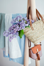Lilac Flower In Handbag Hanging On Clothes Rack
