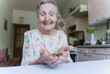 Happy Senior Woman Looking At Coins