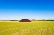 © Westend61 - Manure pile lying in summer field