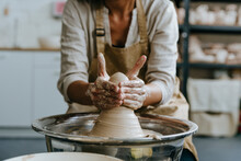 Hands Of Craftswoman Molding Clay On Pottery Wheel At Workshop