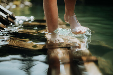 Close-up of barefoot legs walking in lake. Concept of healthy feet.