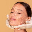 © Prostock-studio - Beauty treatment concept. Young woman receiving face massage from cosmetologist, cropped