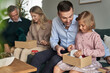 © gpointstudio - Cheerful multi generation caucasian family opening Christmas presents at home