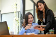 © bongkarn - Asian businesswoman working together, showing some details information on tablet screen