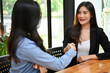 © bongkarn - Gorgeous Asian businesswoman shaking hand with her female coworker.