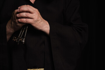 Wall Mural - cropped view of senior priest with keys isolated on black.