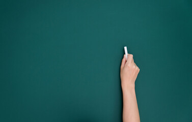 Wall Mural - Woman hand writing by chalk on blackboard