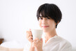 © kapinon - Woman relaxing in her room drinking coffee or other beverages　closeup