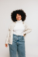 Wall Mural - Self-confident woman with Afro hair smiling at the camera in a studio