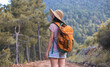 © zhukovvvlad - A woman with a backpack and a straw hat on a mountain path