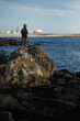 © De Visu - A female tourist stands near the port on the coastal ocean cliffs.