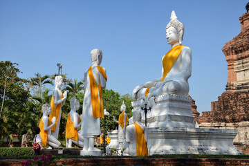 Beautiful scene of Wat Yai Chai Mongkhon (or Mongkhol), a Buddhist temple in Ayutthaya, Thailand. Statues of white monks praying with Buddha.