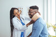 © Dragana Gordic - Doctor applying cervical collar on neck of African American man in clinic. Female doctor putting neck orthopaedic collar on adult injured man. Man in pain at the doctor for a neck injury