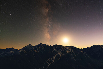 Wall Mural - night landscape. beautiful snow covered mountains in the starry night with milky way galaxy.