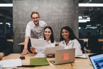 Canvas Print - Smiling diverse coworkers working on project at workplace