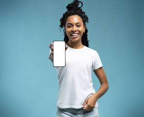 Portrait of excited and surprised young woman holding smartphone with white blank screen in hand, showing device
