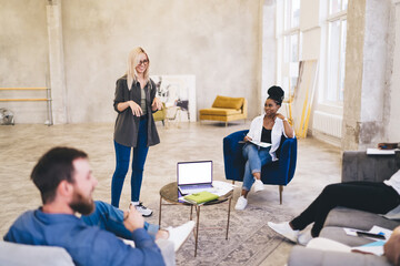 Wall Mural - Cheerful modern colleagues discussing job in spacious office