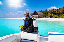 A Scuba Diver In His Diving Gear Sits In Front Of A Boat And Enjoys The View Of The Tropical Landscape With Turquoise Sea