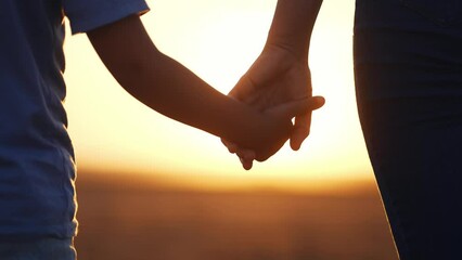 happy family. mom and daughter hold hands close up. mother and baby girl hands together at sunset. p