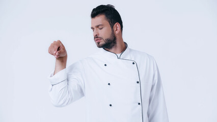 Wall Mural - bearded man in chef jacket seasoning something isolated on white.