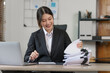 © NanSan - Happy attractive joyful asian woman working at workstation.