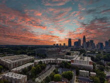 An Aerial Shot Of The Skyscrapers And Office Buildings In The City Skyline With Lush Green Trees And With Powerful Clouds At Sunset At Frazier Park In Charlotte North Carolina USA