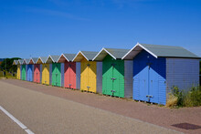 Eastbourne, East Sussex / United Kingdom - July 11 2022: Brightly Coloured Beach Huts On Eastbourne Seafront With Clear Blue Skies.