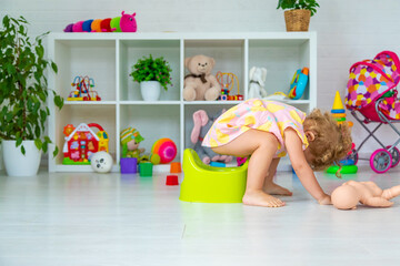 Children sit on the potty in the room. Selective focus.